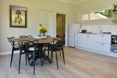 a kitchen and dining room with a table and chairs at Fernkloof Cottage in Hermanus