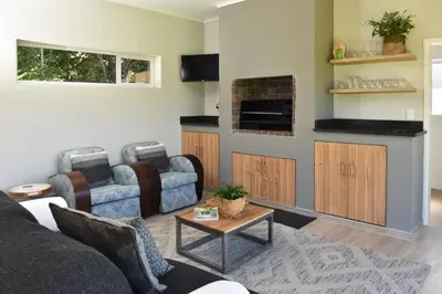 a living room with a couch and a table at Fernkloof Cottage in Hermanus