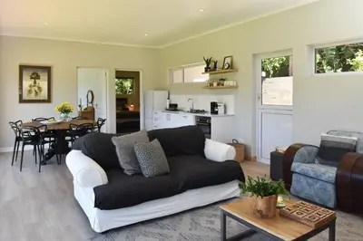 a living room with a couch and a table at Fernkloof Cottage in Hermanus