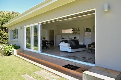 a sliding glass door on a house with a patio at Fernkloof Cottage in Hermanus
