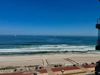 a view of the beach and the ocean at Nautica 2 Bedroom Beachfront Apartment with Sea Views in Bloubergstrand