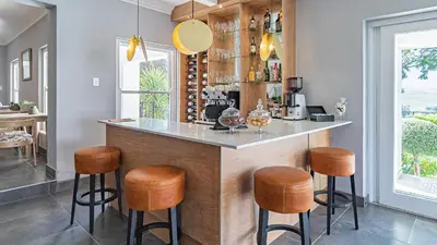 a kitchen with a bar with wooden stools at The Salene Hotel & Apartments in Stellenbosch