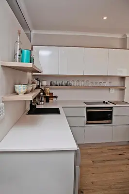 a kitchen with white counters and white cabinets at Aloe Aloe Cottage in Cape Town