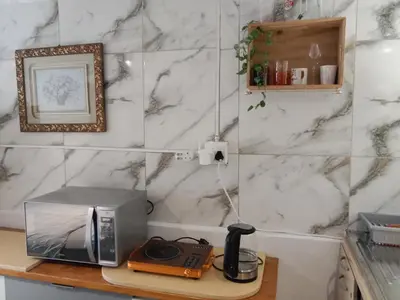 a counter with a microwave and a telephone on a table at Cozy Private En Suite Studio in Cape Town