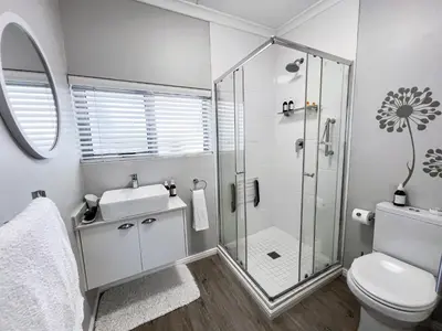 a bathroom with a shower and a toilet and a sink at C'estÇa Cottage Modern Luxurious Sounds of the Sea in Hermanus