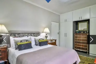 a bedroom with a large bed and a mirror at In die Hoekie in Hermanus
