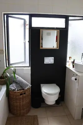 a black bathroom with a toilet and a sink at sonsandsee in Hermanus