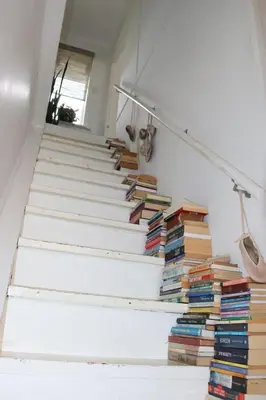 a stack of books on the stairs in a house at sonsandsee in Hermanus