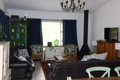 a living room with a couch and chairs and a table at sonsandsee in Hermanus
