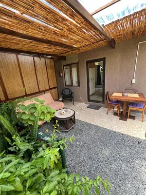 a patio with a table and a wooden ceiling at Santika Garden Cottage Stellenbosch in Stellenbosch