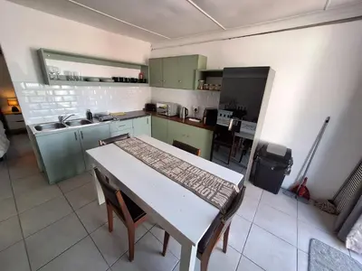 a kitchen with a table and chairs and a kitchen with green cabinets at Little Miracle in Worcester