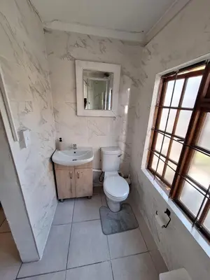 a white bathroom with a toilet and a sink at Little Miracle in Worcester