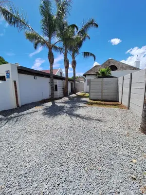 a driveway with palm trees and a fence at Little Miracle in Worcester