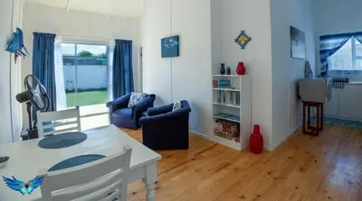 a living room with a table and chairs and a couch at Glenley place in Hermanus