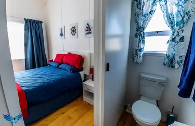 a small bedroom with a bed and a toilet at Glenley place in Hermanus