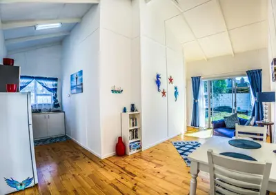 a kitchen and living room with a table and chairs at Glenley place in Hermanus
