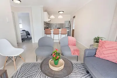 a living room with a couch and chairs and a table at Serengeti selfcatering apartments Perfect Stay in Bellville
