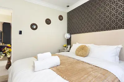 a bedroom with a large white bed with white pillows at Marigold in Brackenfell