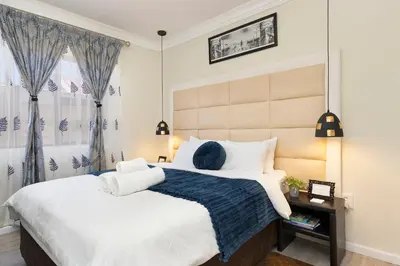 a bedroom with a large bed and a window at Marigold in Brackenfell