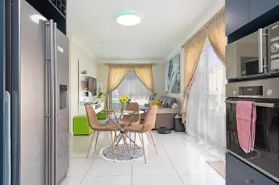 a kitchen and dining room with a table and chairs at Marigold in Brackenfell