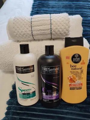 three cleaning products sitting next to a pile of towels at Marigold in Brackenfell