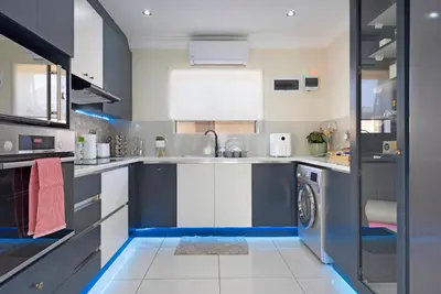 a kitchen with a sink and a washing machine at Marigold in Brackenfell