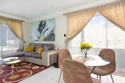 a living room with a couch and a table at Marigold in Brackenfell