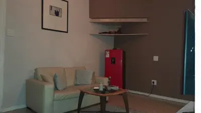 a living room with a couch and a table and a red refrigerator at Limbila House in Cape Town