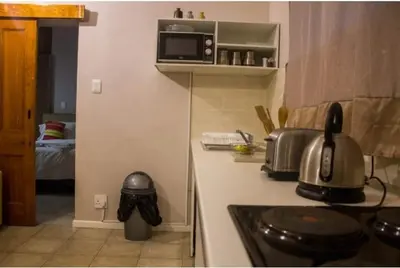a kitchen with a stove and a microwave on a counter at Limbila House in Cape Town