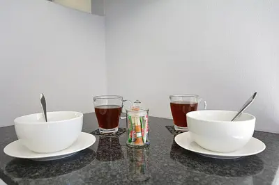 two bowls and two glasses on a table with drinks at Marbella - Cozy studio in Heart of Table View in Cape Town