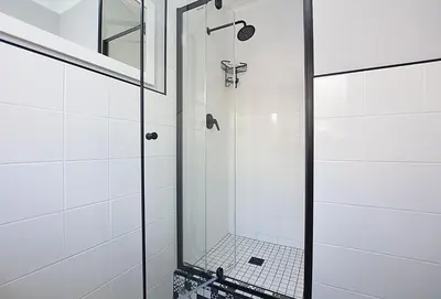 a bathroom with a shower with a glass door at Marbella - Cozy studio in Heart of Table View in Cape Town