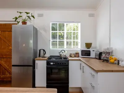 a kitchen with a stove and a refrigerator at Jonkershoek Valley Cottage in Stellenbosch
