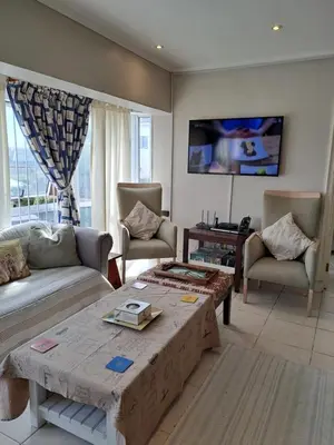 a living room with a couch and a table at Palmsbeach 3 in Strand