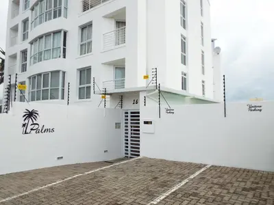 a white building with a parking lot at Palmsbeach 3 in Strand