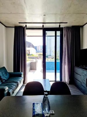 a living room with a couch and a table at Bridgewater One by Smart City Stays in Cape Town