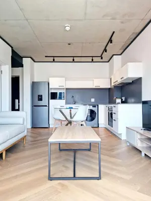 a living room with a table and a couch at Bridgewater One by Smart City Stays in Cape Town