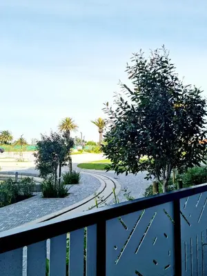 a balcony with a fence and trees and a road at Bridgewater One by Smart City Stays in Cape Town