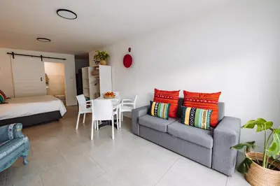 a living room with a couch and a table at McLeod's & Stuart's Cottage in Somerset West