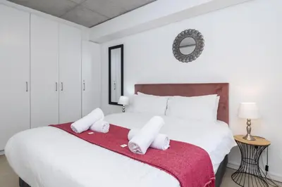 a bedroom with a large white bed with towels on it at Sea and Sun-Table Mountain views Wifi Parking! in Cape Town