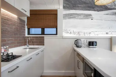 a white kitchen with a sink and a window at Hornbill House Self Catering Accommodation in Hermanus