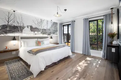a bedroom with a large white bed and windows at Hornbill House Self Catering Accommodation in Hermanus