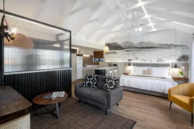 a hotel room with a bed and a chair at Hornbill House Self Catering Accommodation in Hermanus