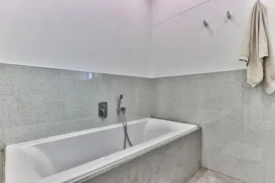 a white bath tub in a bathroom with a towel at Family Home, WiFi, Patio, Secure Parking in Cape Town