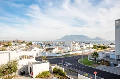 an aerial view of a suburb with mountains in the background at Beachfront 2 bed w swimming pool, Blouberg 54 Beach Break in Bloubergstrand