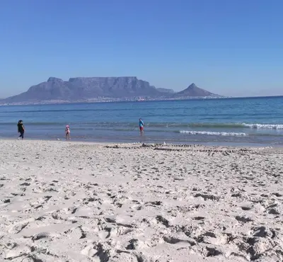 a group of people walking on the beach at Teas & Seas Self Catering Cottage in Cape Town