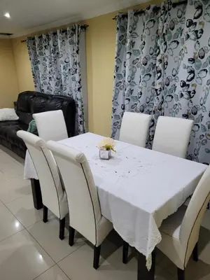 a dining room with a white table and chairs at Jacmo Guest Private Rooms in Cape Town