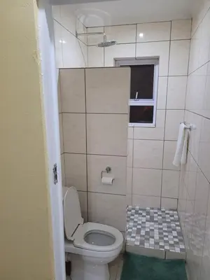 a small bathroom with a toilet and a window at Jacmo Guest Private Rooms in Cape Town