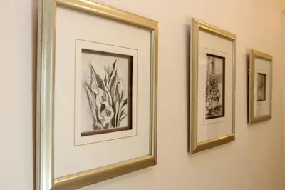 a group of framed pictures hanging on a wall at Die Kelderhuis in Breerivier