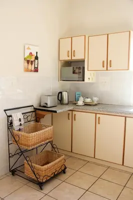 a kitchen with white cabinets and a counter top at Die Kelderhuis in Breerivier