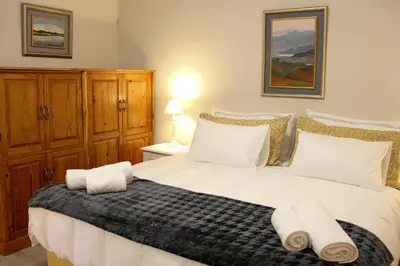 a bedroom with a large white bed with towels on it at Die Kelderhuis in Breerivier